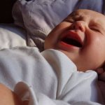 Why does a 5 month old baby sleep poorly at night?