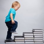 A child walks along steps made from books
