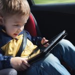 child playing on tablet on the road